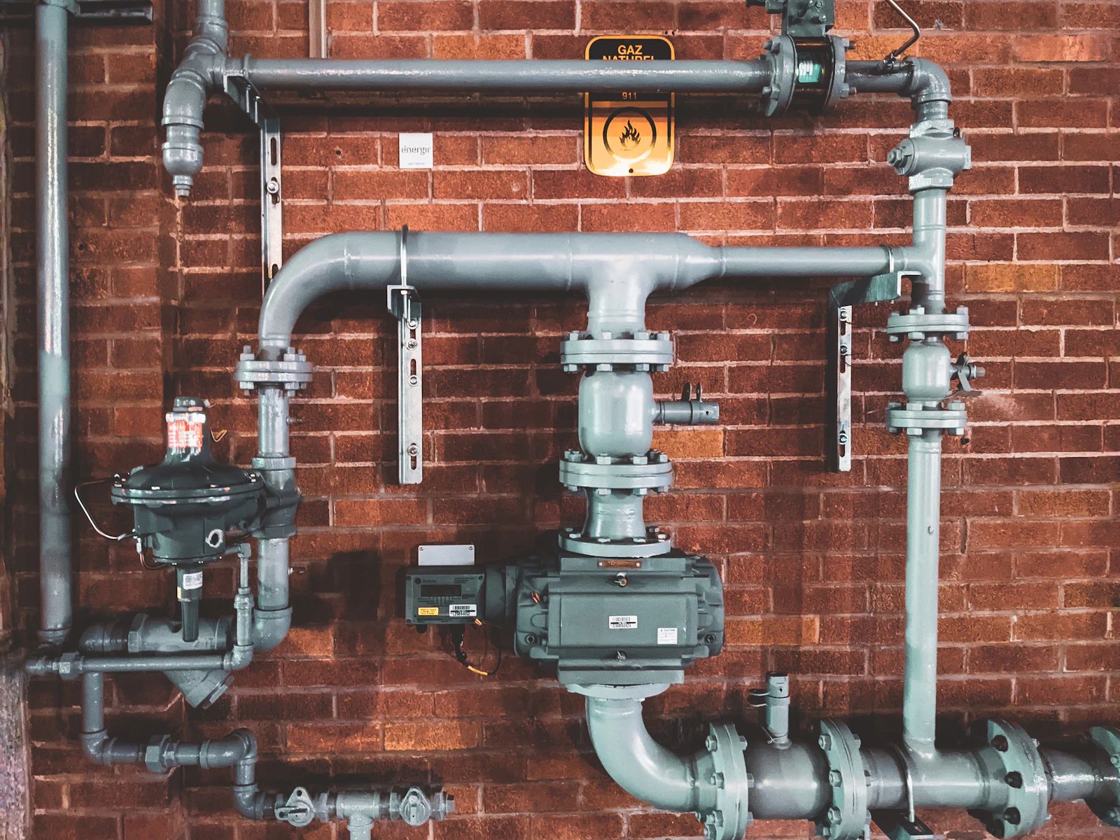 Pipework mounted on a wall, the kind of system Lopez Plumbing installs, repairs, and maintains.